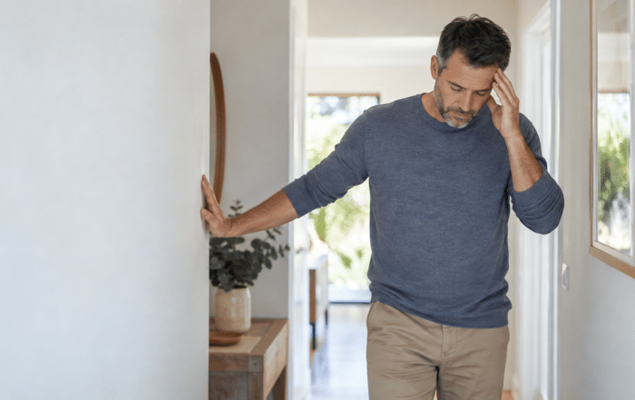 Man pausing for support after feeling lightheaded when standing up