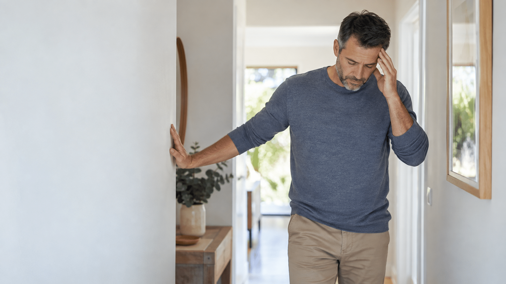 Man pausing for support after feeling lightheaded when standing up